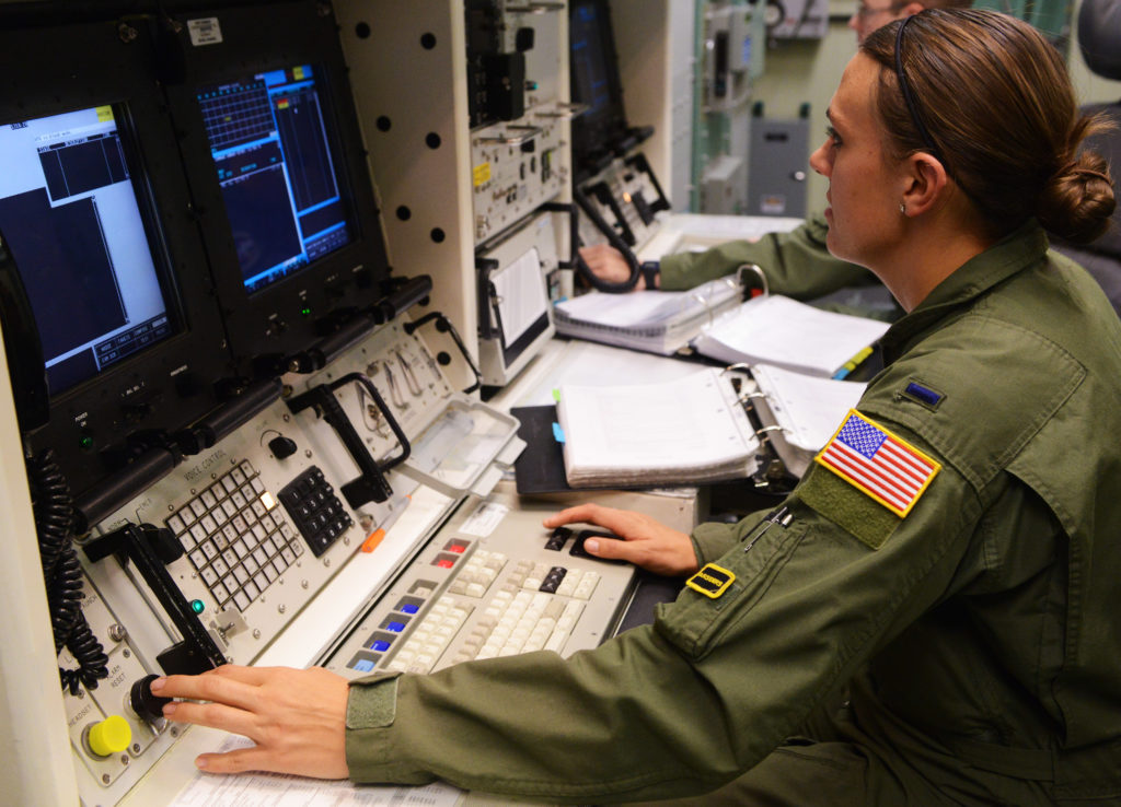 A combat missile crew commander using the trackball of the REACT console