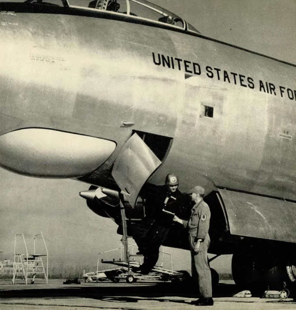 Col. Paul Tibbets accepts the B-47 aircraft forms from the crew chief as he enters the plane.