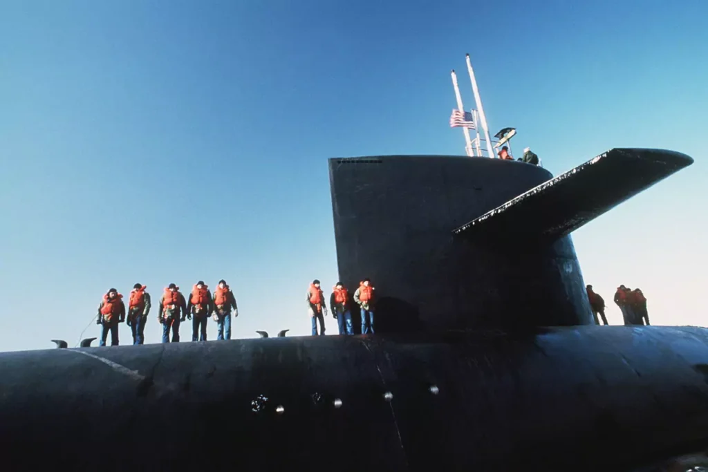 Crewmen stand on deck as USS GEORGIA (SSBN 729) comes into port in 1984